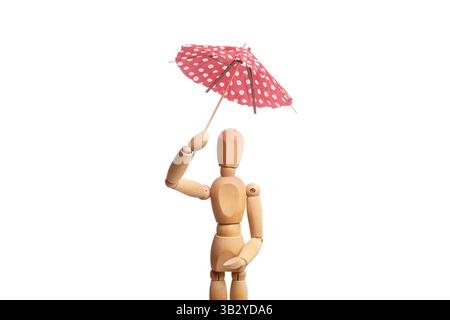 A wooden mannequin toy holding an umbrella in his hand on white background Stock Photo