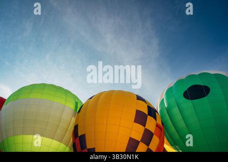 Colorful hot air balloons against blue sky at outdoor festival Stock Photo