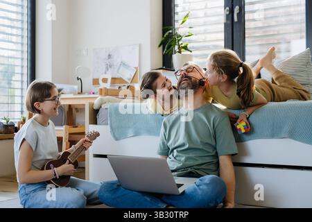 Father with three daughters trying to work from homeoffice. Stock Photo