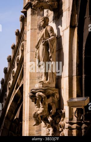 Milan, Italy - 19.03.2024: Architectural stone statue on historic building facade with ornate details, Milan Duomo Cathedral Stock Photo