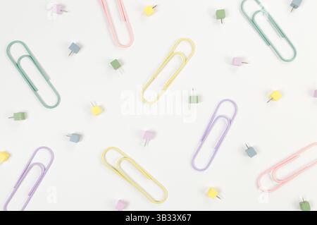 Top view of paperclips and pins on white background. School, office wallpaper. Flat lay, copy space. Stock Photo