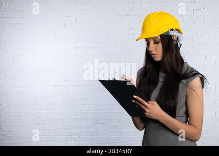 An experienced Construction Professional with a Clipboard and Safety Helmet for site safety Stock Photo