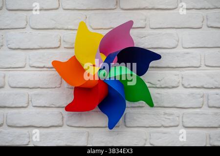 pinwheel with six vibrant blades—red, orange, yellow, pink, purple, blue, and green Stock Photo