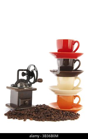 Stacked cups and saucers with coffee beans isolated over white background Stock Photo