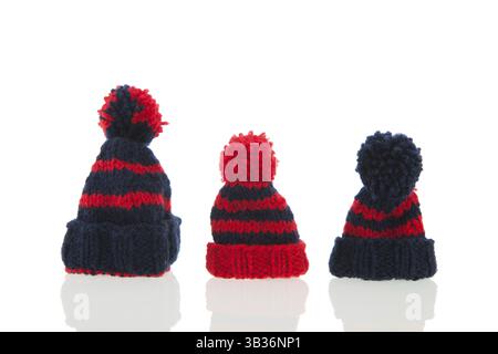 Red and blue knitted winter hats isolated over white background Stock Photo