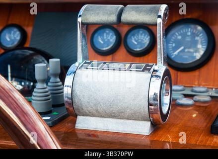 Motor yacht control panel. Steering wheel, gear levers, gauges, speedometers and control buttons. Stock Photo