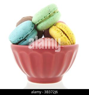 Colorful French macaroons in bowl isolated over white background Stock Photo