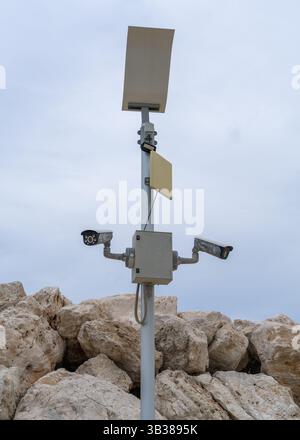 Street surveillanc cameras hang on pole on city embankment. Security concept is control and protection. Stock Photo