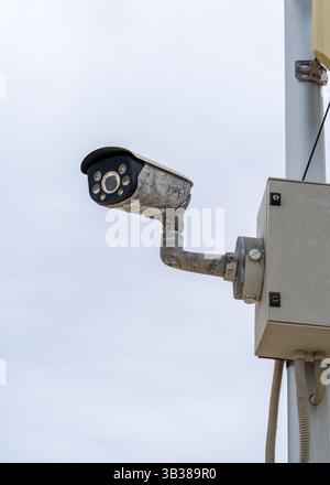 Surveillance cameras mounted on a pole along an urban waterfront. Symbol of security, monitoring, and public safety. Stock Photo