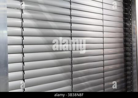 Light filtering through pastel colored venetian blinds in domestic interior. Industry Stock Photo