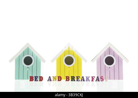 Bed and breakfast in little colorful birdhouses isolated over white background Stock Photo