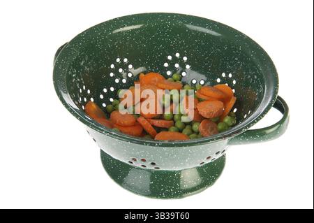 Green colander with fresh carrottes and green peas Stock Photo