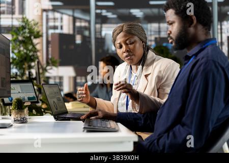 African american business team collaborates on global expansion strategy, using their extensive expertise to work on data driven decisions. Colleagues solving administrative tasks. Stock Photo