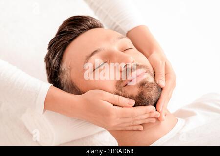 Spa therapist making relaxing massage for handsome man Stock Photo