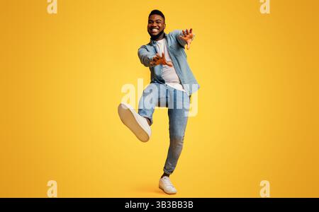 Funny black man dancing and extending his hands to camera Stock Photo