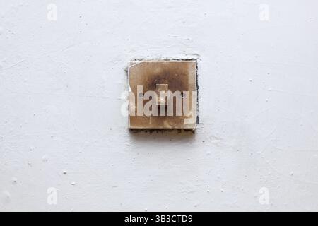 old light switch mounted on white wall Stock Photo