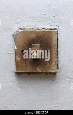 old light switch mounted on white wall Stock Photo