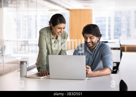 Two Indian workmates working on joint task using laptop Stock Photo