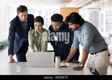 Creative marketing department using laptop working together on project Stock Photo