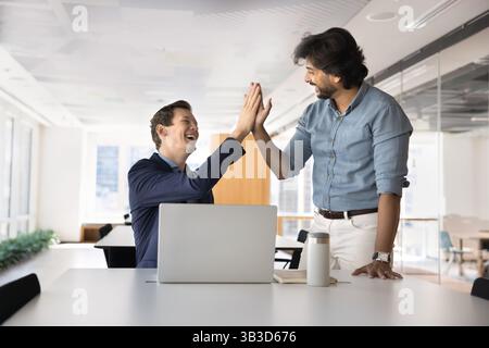Two businessmen exchanging high five in office Stock Photo