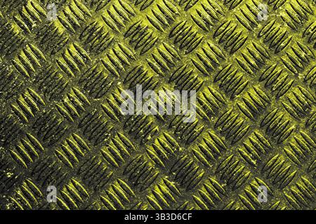 Painted sprayed steel checker plate grunge background. worn yellow sprayed industrial material concept Stock Photo