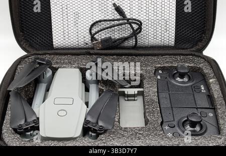 Gray drone and remote control in protective case with accessories. Stock Photo