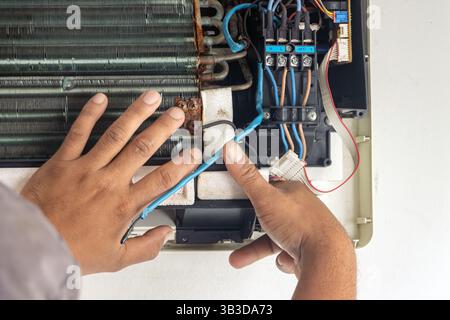 Hands of a repairman performing air conditioning maintenance Stock Photo