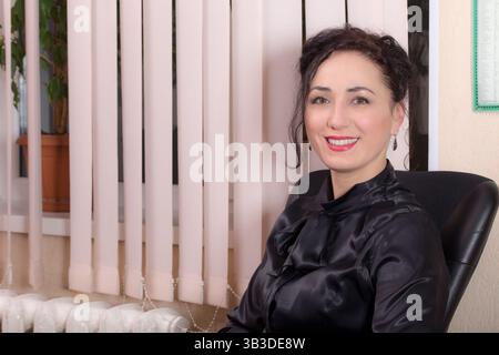 Smiling business woman sitting in the office. Photo can be used as a whole background. Stock Photo