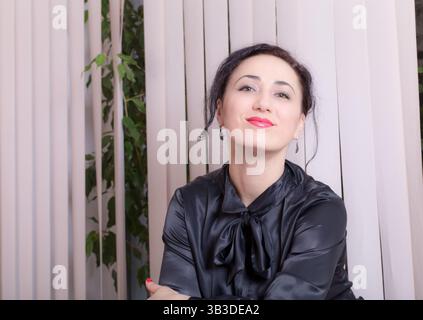 Smiling business woman sitting in the office. Photo can be used as a whole background. Stock Photo