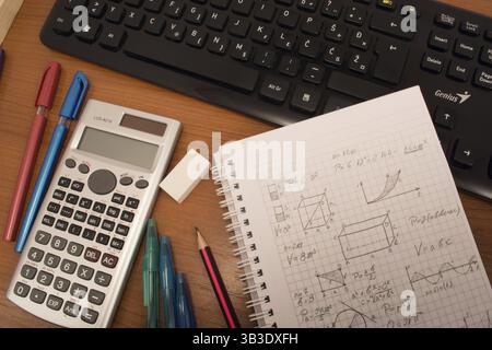 Computer keyboard, calculator, colorful pencils, eraser and notebook on the table Stock Photo