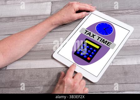Tax time concept shown on a tablet used by a woman Stock Photo
