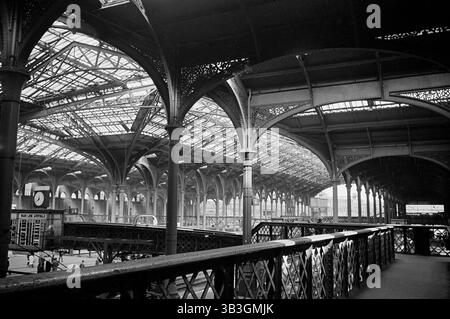 The interior of Liverpool Street Station showing the footbridge over the Continental Boat Train arrival platform and the ornate cast iron roof structure, London, 1960-1972. Stock Photo