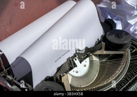 Vintage typewriter with the phrase, seeking inspiration, typed on white paper, with crumpled sheets nearby, writer’s block, creative struggle Stock Photo