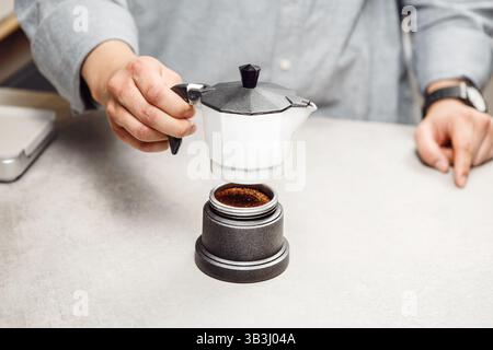 Preparing Fresh Brew With Traditional Italian Coffee Maker in Modern Kitchen Stock Photo