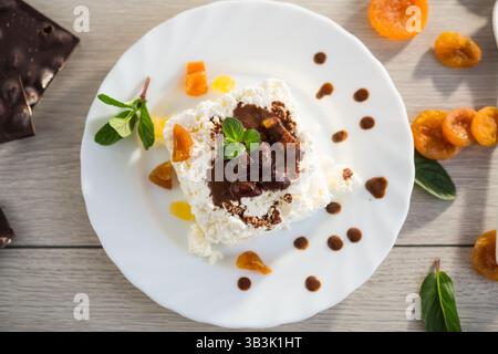 sweet breakfast in a plate with cottage cheese in chocolate syrup with candied fruits. Stock Photo