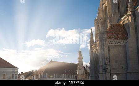 Sun rays are beaming down on the ornate matthias church facade in the castle hill district of budapest, hungary Stock Photo