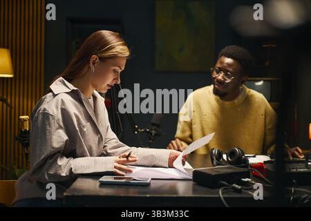 Colleagues Reading Text Before Podcast Stock Photo