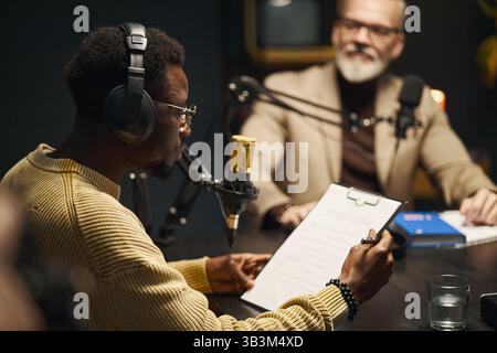 Man Reading Plan Before Podcast Stock Photo