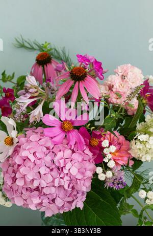 A bouquet of summer flowers in the room. Hydrangea, rose, echinacea, mint, snapdragon, asparagus and other flowers. Stock Photo