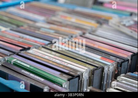 A considerable number of CDs are neatly stacked one on top of another, creating a tidy display that showcases them beautifully Stock Photo