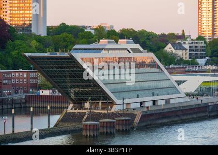 Hamburg, Germany - April 27, 2025: The Dockland building in Hamburg with its modern glass facade towers over the Elbe and serves as an office building with a publicly accessible roof terrace on the harbor *** Das Dockland-Gebäude in Hamburg mit moderner Glasfassade ragt über die Elbe hinaus und dient als Bürohaus mit öffentlich zugänglicher Dachterrasse am Hafen Stock Photo