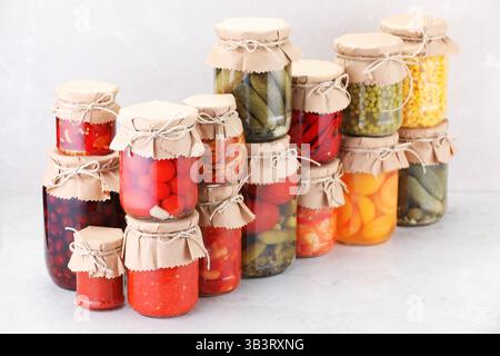Many jars with different pickled products on light table Stock Photo