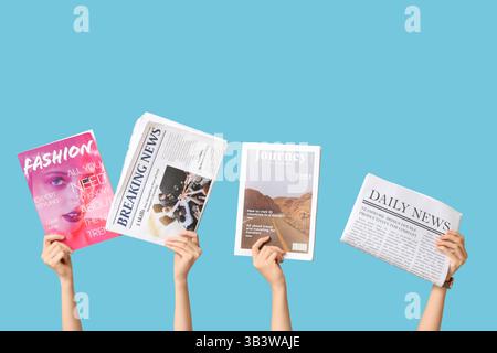Female hands with different magazines and newspapers on blue background Stock Photo