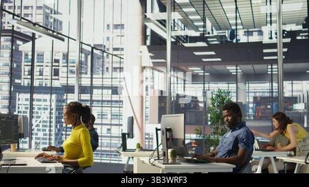 African american man designing, developing and maintaining software applications using various programming languages. System administrator debugging company servers, preventing failures, camera B Stock Photo