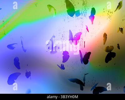 A vibrant image featuring numerous butterfly silhouettes set against a colorful, abstract background with a rainbow effect, and textured elements. Stock Photo