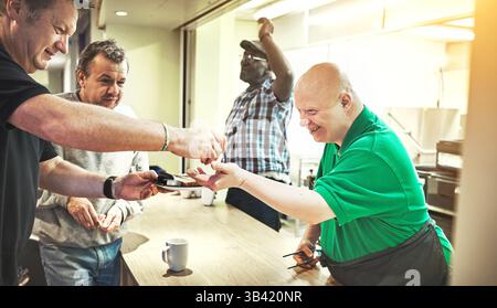 Community, volunteer and help with a down syndrome man in a kitchen of a home for learning, development and activism. Charity, relief and aid with a Stock Photo