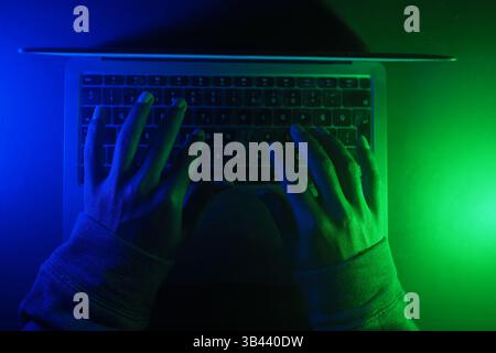 hacker Hands working on a laptop, cyber crime concept  Stock Photo