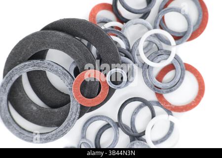 Close-up shot of various rubber and fiber gaskets in different sizes and colors, all on a white background. Stock Photo