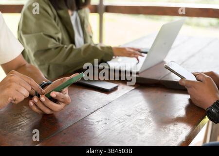Social media concept. Group of friends using mobile phone and laptop. Community of like minded young people, watching and discussing videos together, Stock Photo
