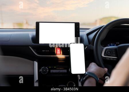 Car multimedia monitors screen with empty space for message. Modern smartphone device gadget mounted on phone holder at car dashboard. Clipping path. Stock Photo